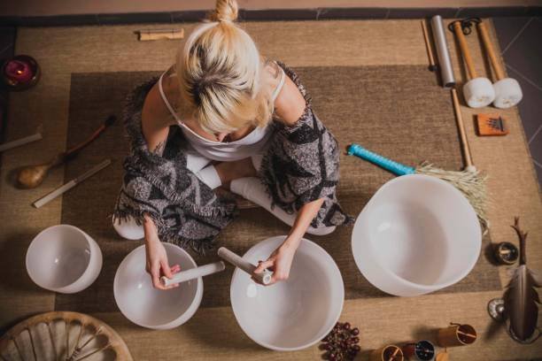 adult woman playing singing crystal bowl