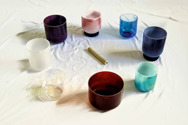 a collection of colorful crystal singing bowls against white backdrop.